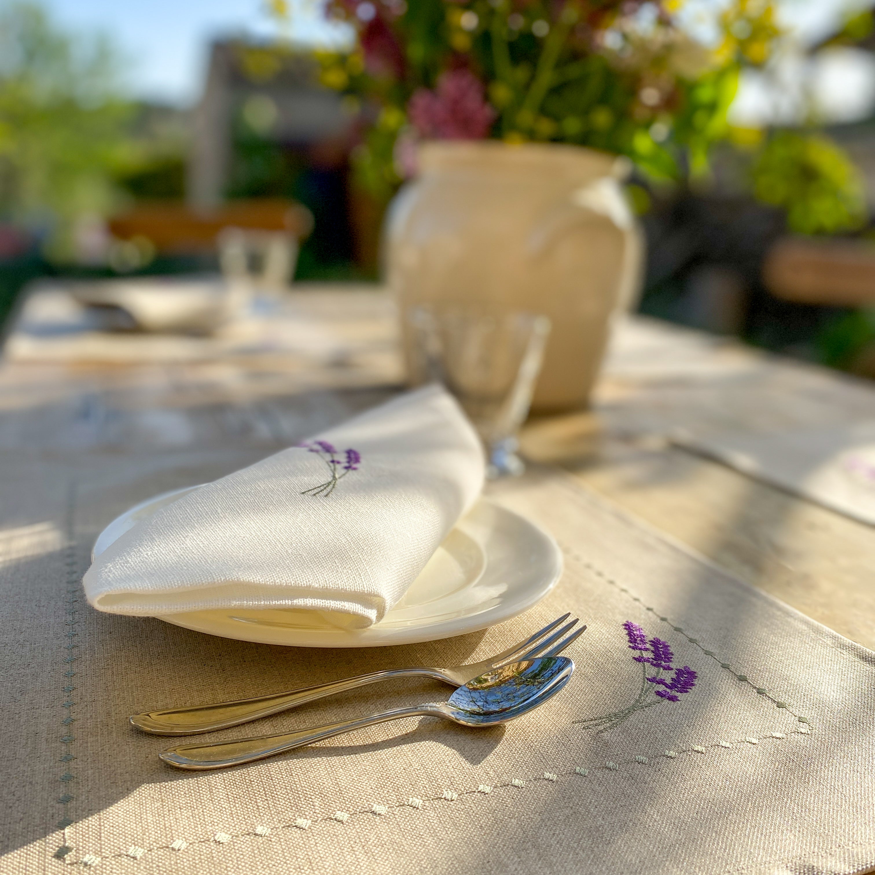 Tischset aus 100 % gewaschenem Leinen in Naturfarbe, verziert mit einer zarten Lavendel-Stickerei in Violetttönen. Das Design verbindet provenzalische Leichtigkeit mit handwerklicher Eleganz – ideal für eine stilvolle Tischdekoration.