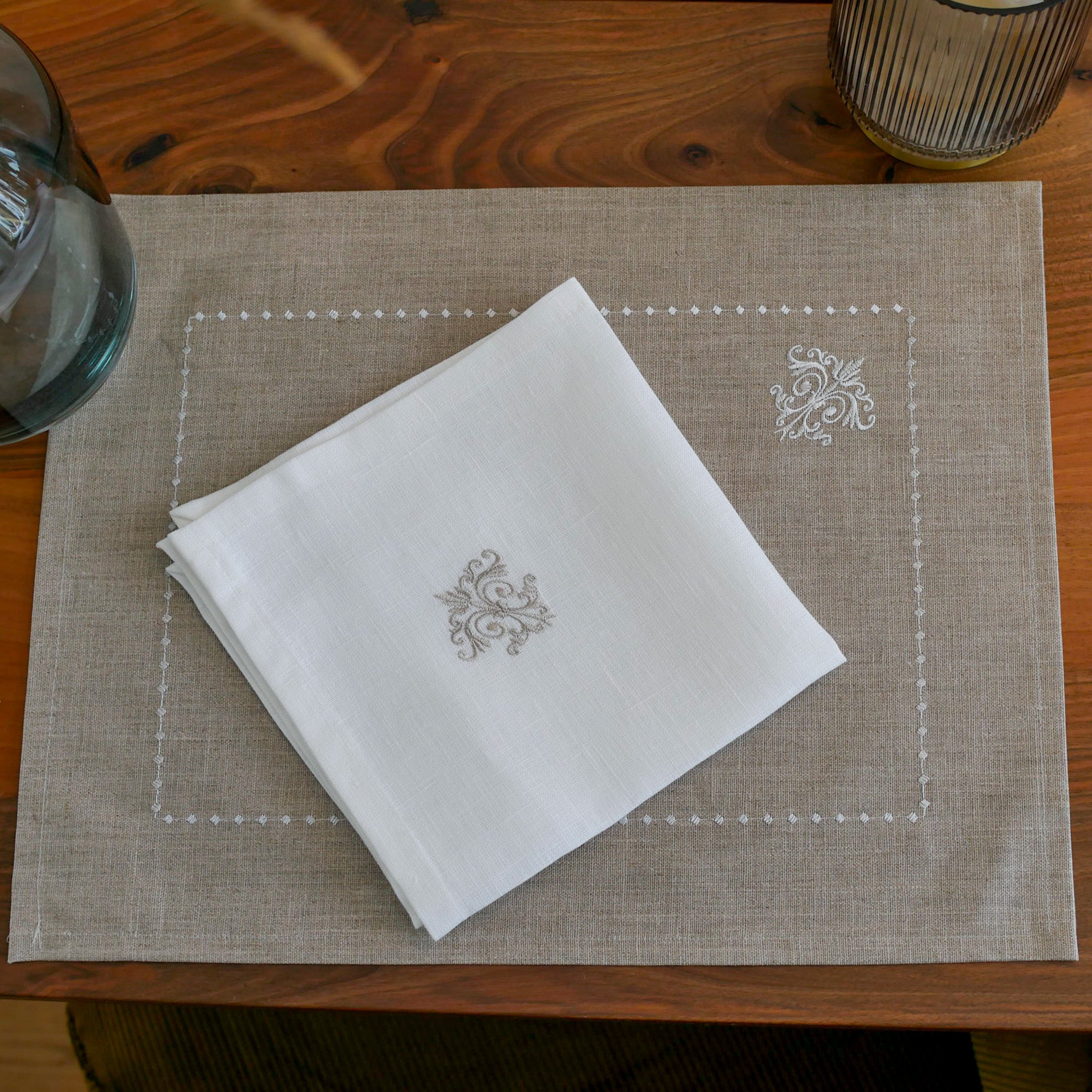 Serviette aus weißem Leinen mit feinem Ornamentmuster – elegant, zeitlos und hochwertig verarbeitet.