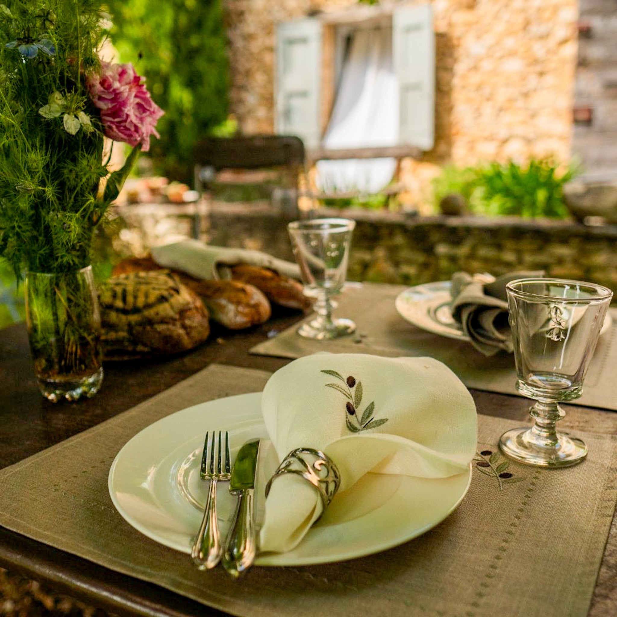 Tischset aus 100 % gewaschenem Leinen in Naturton, verziert mit einem feinen olivfarbenen Stickmuster. Das dezente Design bringt mediterrane Eleganz und handwerkliche Raffinesse auf den gedeckten Tisch.